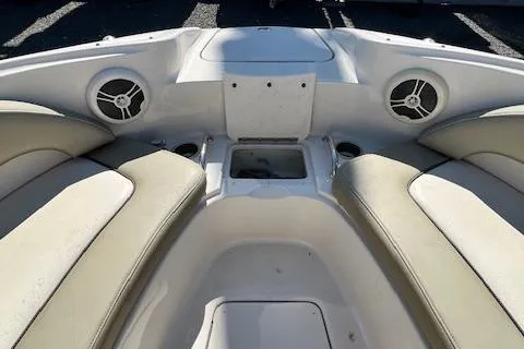 Slide: The Image of 2006 Sea Ray 220 Sundeck interior with beige seating and built-in speakers. - 11