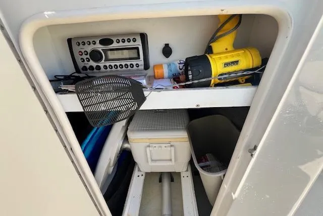 Slide: The Image of Storage compartment in a 2006 Sea Ray 220 Sundeck with tools and equipment. - 13