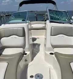 Slide: The Image of 2006 Sea Ray 220 Sundeck boat interior with seating, docked by the water. - 5