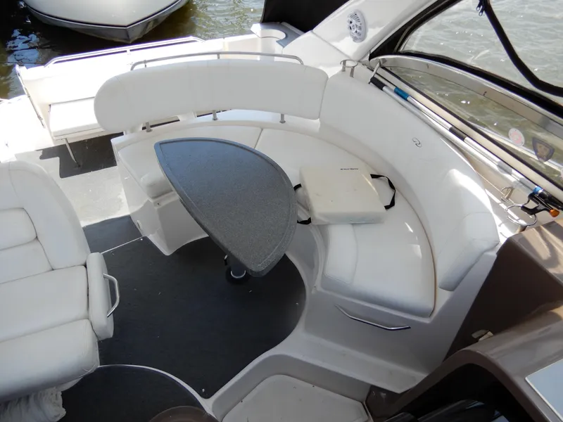 Slide: The Image of 2006 Regal Commodore 3760 IO boat interior with white seating and a small table. - 15