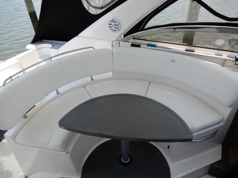 Slide: The Image of 2006 Regal Commodore 3760 IO boat interior with white seating and a small table. - 17