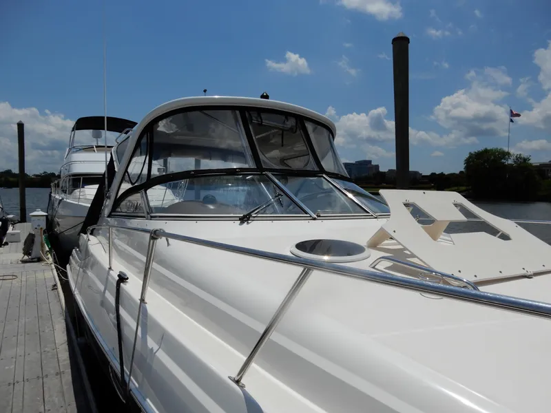 Slide: The Image of 2006 Regal Commodore 3760 IO yacht docked under a clear blue sky. - 2