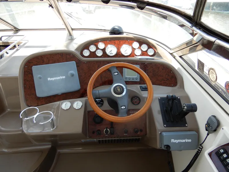 Slide: The Image of 2006 Regal Commodore 3760 IO helm with Raymarine electronics and wood-accented steering wheel. - 20