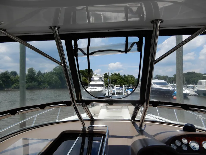 Slide: The Image of 2006 Regal Commodore 3760 IO yacht interior view at marina, surrounded by boats and trees. - 27