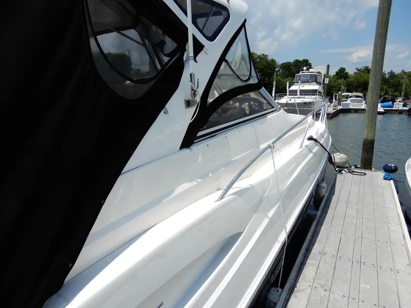 Slide: The Image of 2006 Regal Commodore 3760 IO yacht docked at marina under clear sky. - 3