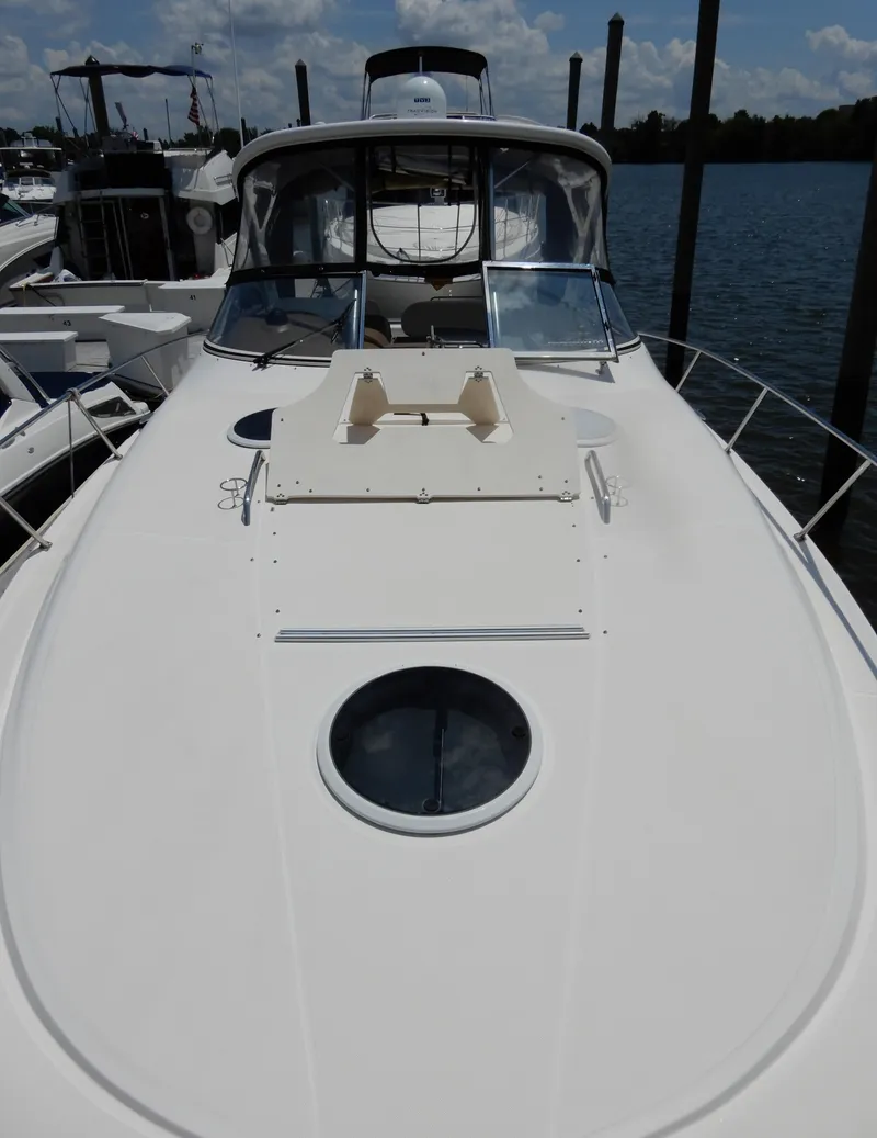 Slide: The Image of 2006 Regal Commodore 3760 IO boat docked, showcasing sleek deck design and cabin entrance. - 4