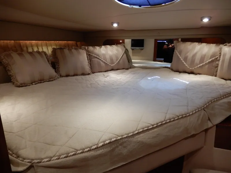 Slide: The Image of Luxurious cabin interior of 2006 Regal Commodore 3760 IO with plush bedding and ambient lighting. - 40