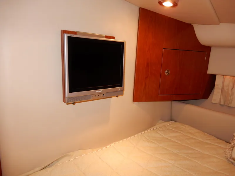 Slide: The Image of 2006 Regal Commodore 3760 IO cabin with wall-mounted TV and cozy bedding. - 42
