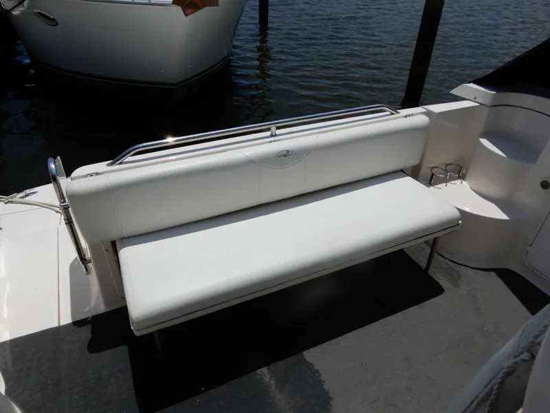 Slide: The Image of White seating area on 2006 Regal Commodore 3760 IO boat, docked by water. - 9