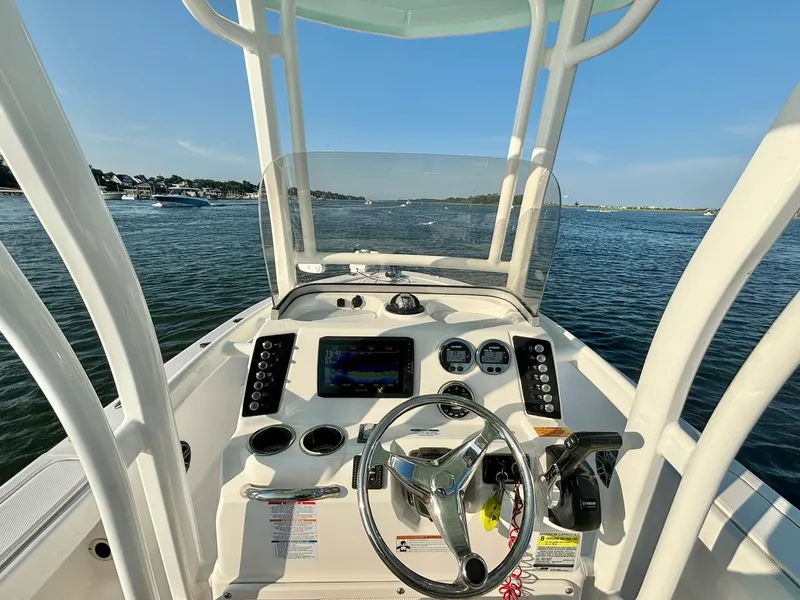 Slide: The Image of 2020 Robalo 226 Cayman boat dashboard with steering wheel, gauges, and controls on open water. - 11