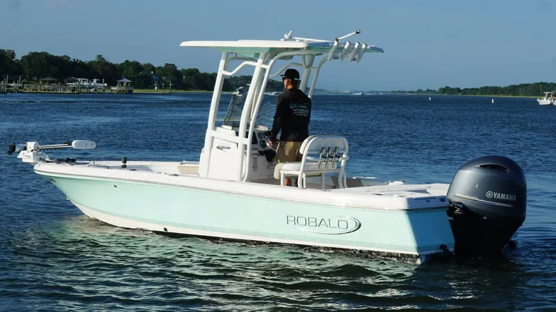 Slide: The Image of 2020 Robalo 226 Cayman boat cruising on a serene lake with Yamaha engine. - 4