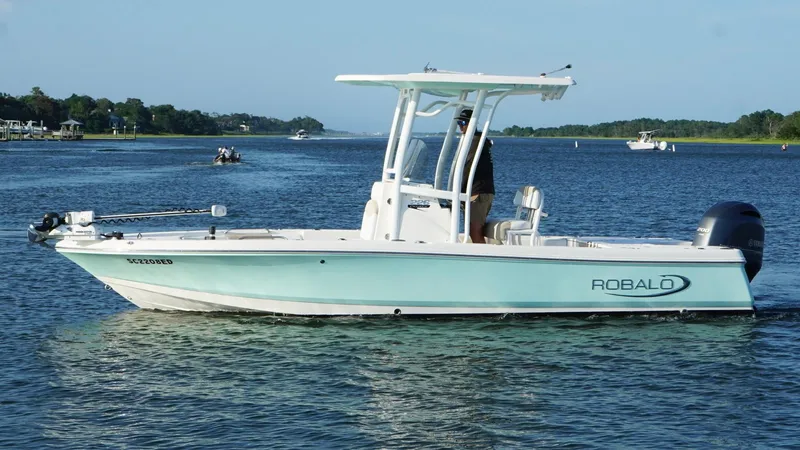 Slide: The Image of 2020 Robalo 226 Cayman boat cruising on a scenic waterway. - 8
