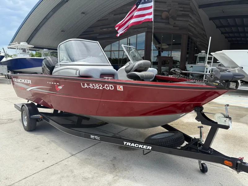 Slide: The Image of 2015 Tracker Targa V18 Combo boat on trailer, parked outdoors under cloudy sky. - 2