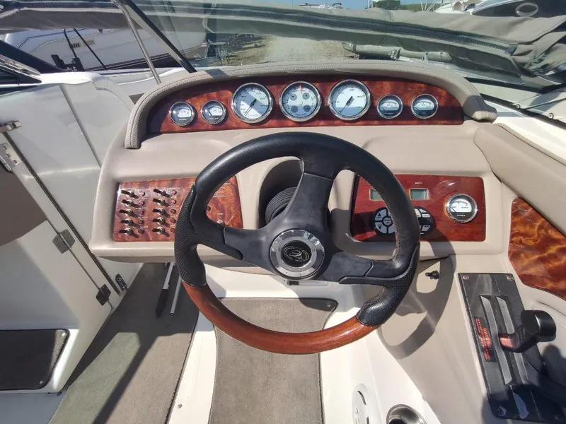 Slide: The Image of Steering wheel and dashboard of a 2000 Cobalt 262 boat, featuring wood accents and gauges. - 2