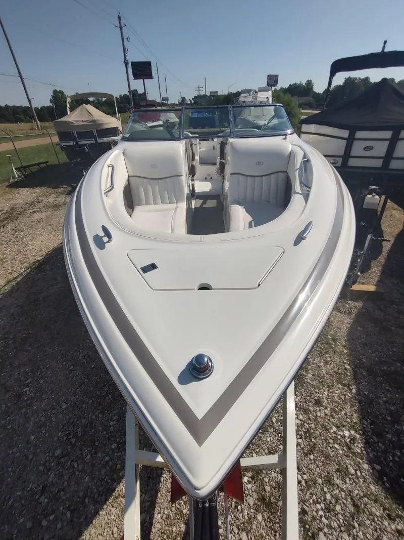 Slide: The Image of 2000 Cobalt 262 boat with white interior, parked on gravel lot under clear sky. - 31