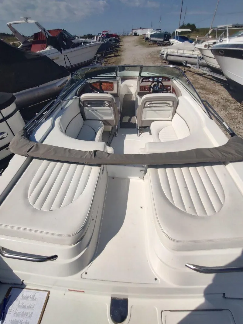 Slide: The Image of 2000 Cobalt 262 boat with white interior, parked in a marina under a clear sky. - 33