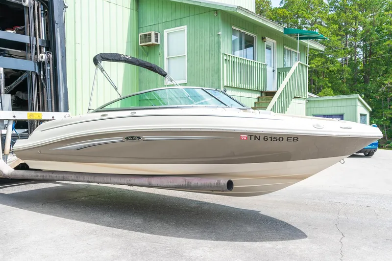 The Image of 2009 Sea Ray 210 Select boat on a lift near a green building. - 1