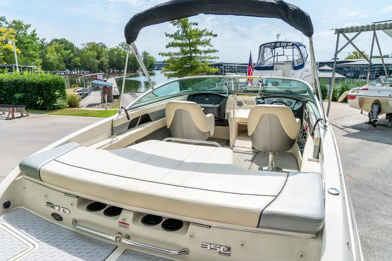 Slide: The Image of 2009 Sea Ray 210 Select boat docked at marina, rear view with seating and canopy. - 10