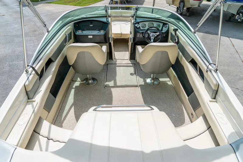 Slide: The Image of 2009 Sea Ray 210 Select boat interior with beige seating and steering console. - 12
