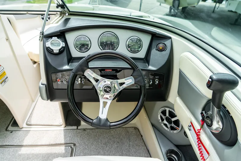 Slide: The Image of 2009 Sea Ray 210 Select boat dashboard with steering wheel and control panel. - 16