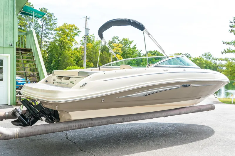 Slide: The Image of 2009 Sea Ray 210 Select boat on trailer, parked outdoors near green building. - 3