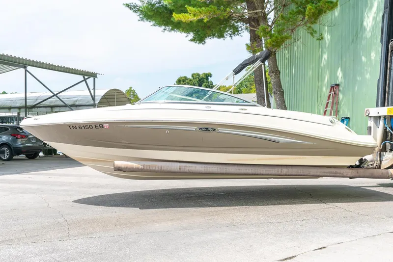 Slide: The Image of 2009 Sea Ray 210 Select boat on trailer, parked outdoors near trees and a building. - 5