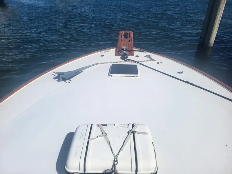 Slide: The Image of Bow of 1989 Ocean Yachts 48 on calm water, featuring anchor and hatch. - 13