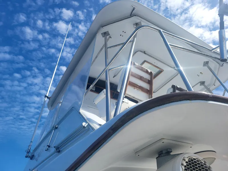 Slide: The Image of 1989 Ocean Yachts 48 boat against a bright blue sky with scattered clouds. - 21
