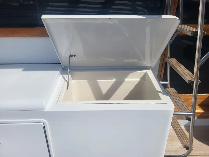 Slide: The Image of Open storage compartment on 1989 Ocean Yachts 48, near wooden steps. - 23