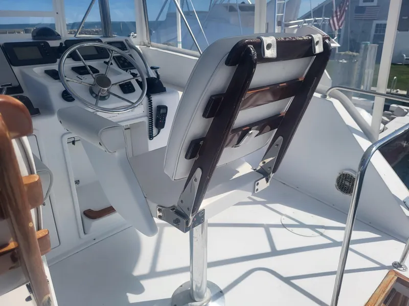 Slide: The Image of Captain's chair and helm of 1989 Ocean Yachts 48, featuring steering wheel and controls. - 31