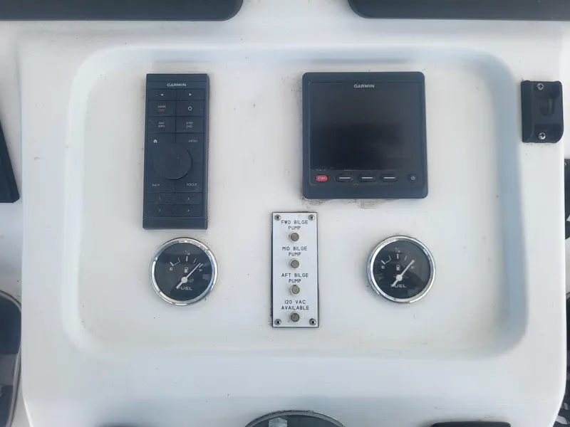 Slide: The Image of Control panel of a 1989 Ocean Yachts 48 with Garmin devices and fuel gauges. - 39