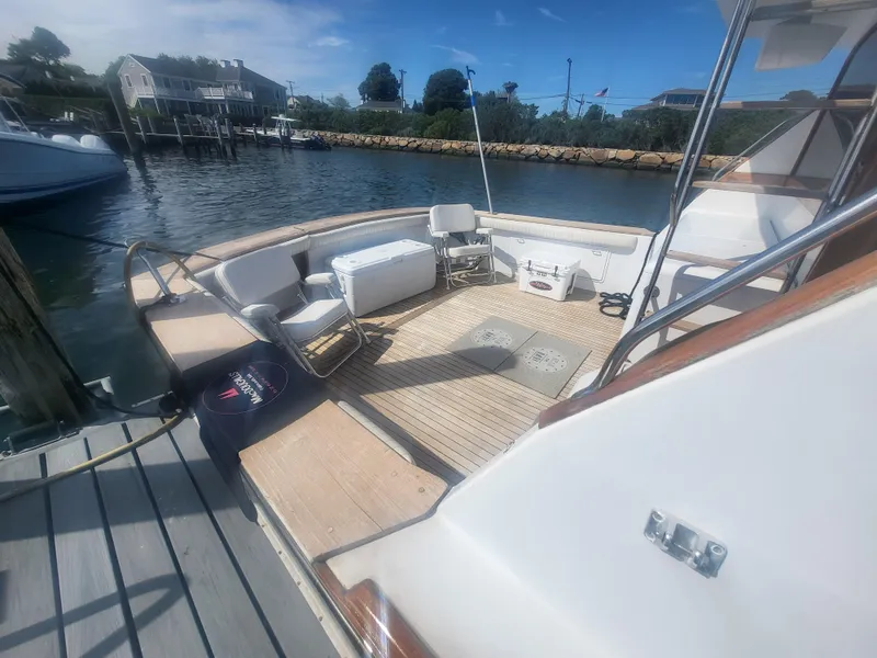 Slide: The Image of 1989 Ocean Yachts 48 boat deck with seating and cooler, docked in a marina. - 4