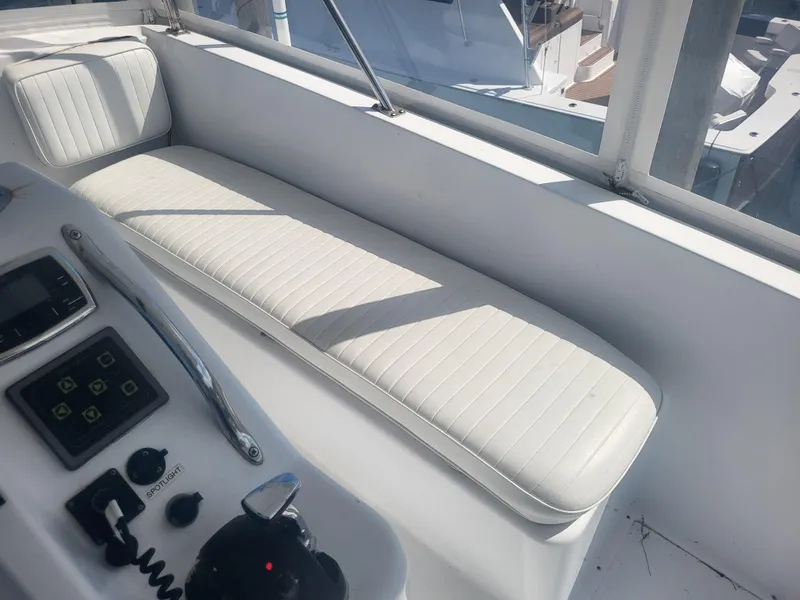 Slide: The Image of White seating area on 1989 Ocean Yachts 48 boat, featuring control panel and sunlight. - 43