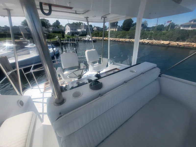 Slide: The Image of 1989 Ocean Yachts 48 interior with white seating, docked near waterfront homes. - 48