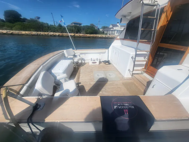 Slide: The Image of 1989 Ocean Yachts 48 boat deck with seating, ladder, and scenic waterfront view. - 5