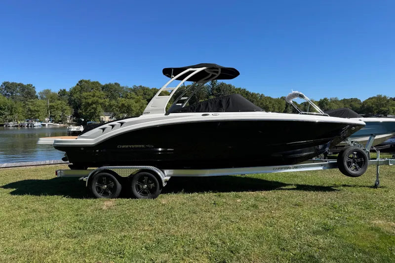Slide: The Image of 2026 Chaparral 23 SSi boat on trailer by a lake, under clear blue sky. - 19