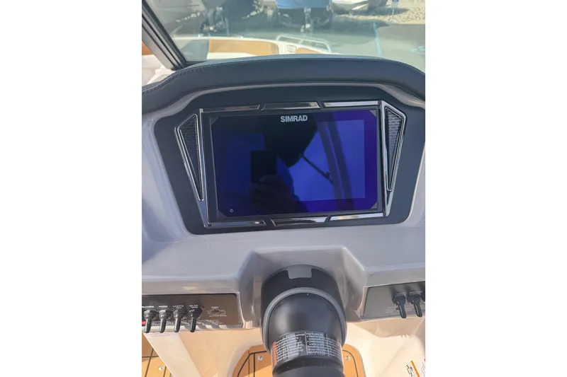 Slide: The Image of 2026 Chaparral 23 SSi boat dashboard featuring a Simrad display and control panel. - 27