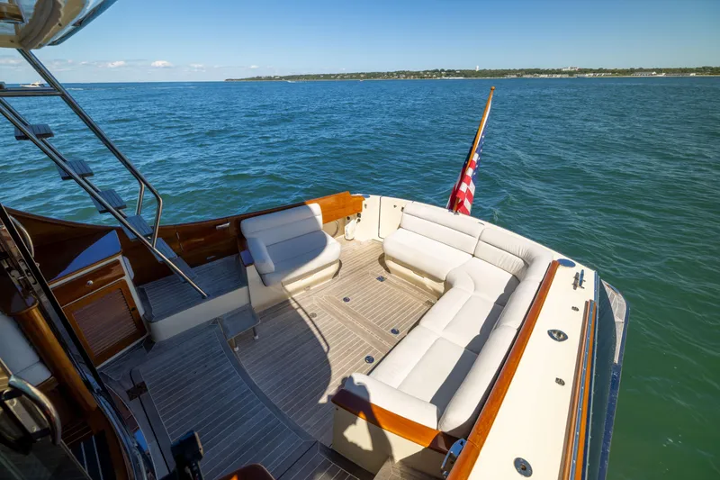 Slide: The Image of Hinckley Talaria 48 Flybridge 2014 yacht with spacious deck and seating, cruising on open water. - 11
