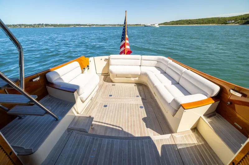 Slide: The Image of 2014 Hinckley Talaria 48 Flybridge yacht with spacious deck seating and American flag. - 12