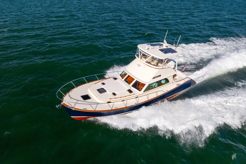 Slide: The Image of 2014 Hinckley Talaria 48 Flybridge cruising on open water, showcasing elegant design. - 3