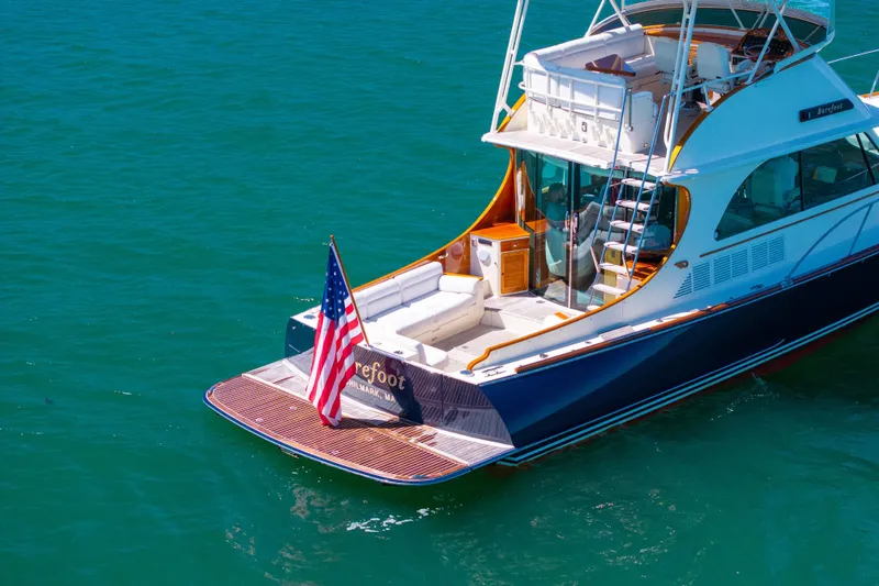 Slide: The Image of 2014 Hinckley Talaria 48 Flybridge yacht on clear blue water with American flag. - 7