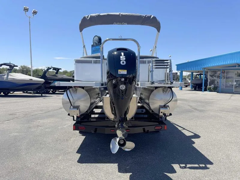Slide: The Image of 2025 Avalon 2385 25 LSZ QL pontoon boat with 150 HP engine, parked outdoors. - 11