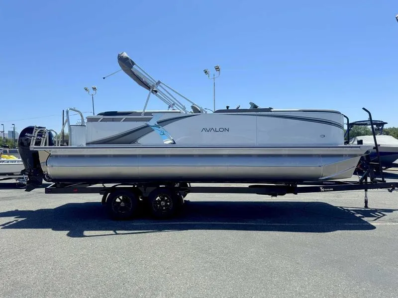 Slide: The Image of 2025 Avalon 2385 25 LSZ QL pontoon boat on trailer, under clear blue sky. - 6