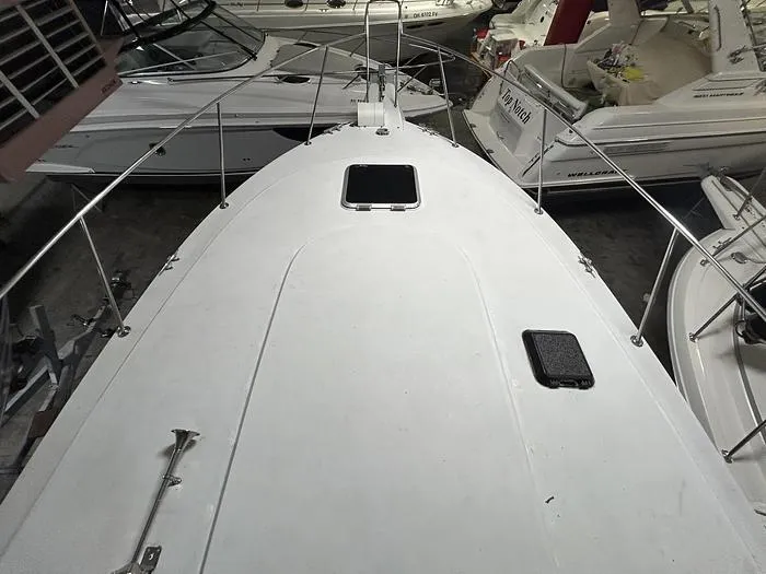 Slide: The Image of 1990 Carver 3257 Montego boat deck view in storage, surrounded by other boats. - 10