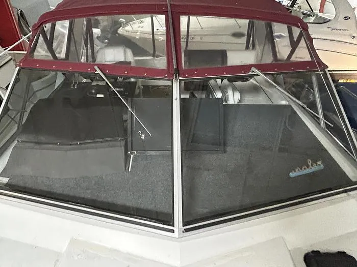 Slide: The Image of 1990 Carver 3257 Montego boat with red canopy and clear windshield. - 13