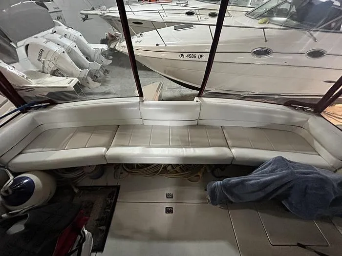 Slide: The Image of Interior of a 1990 Carver 3257 MONTEGO boat with white seating and docked vessels. - 16