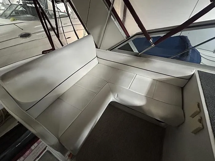 Slide: The Image of Interior seating of a 1990 Carver 3257 MONTEGO boat, featuring white upholstery. - 18