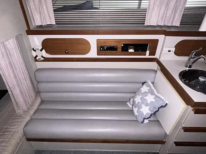 Slide: The Image of Interior of a 1990 Carver 3257 MONTEGO with gray seating and star-patterned pillow. - 22