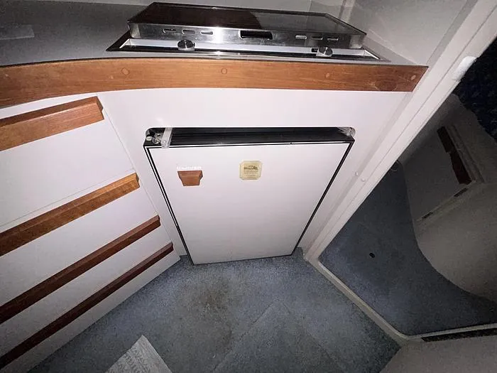 Slide: The Image of 1990 Carver 3257 MONTEGO interior with compact kitchen and fridge. - 24