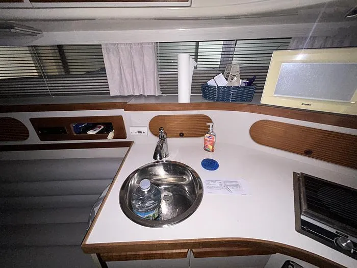 Slide: The Image of Interior of a 1990 Carver 3257 MONTEGO boat kitchen with sink and countertop items. - 25